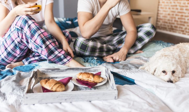 Couple and thier dog Eating Breakfast in bed